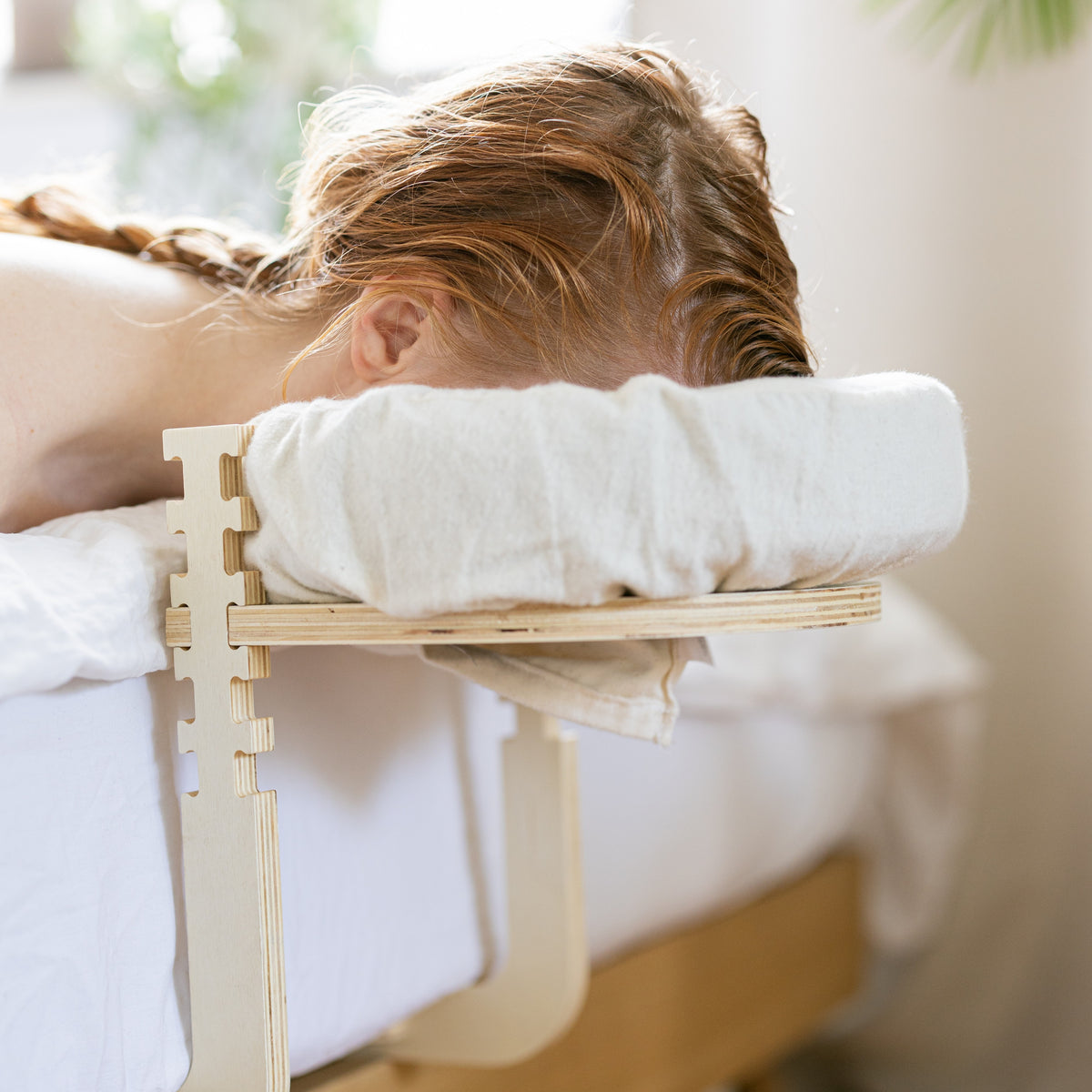 Frau liegt im Bett mit dem Gesicht in der Kopfstütze des Ezspa Bettmassage Sets